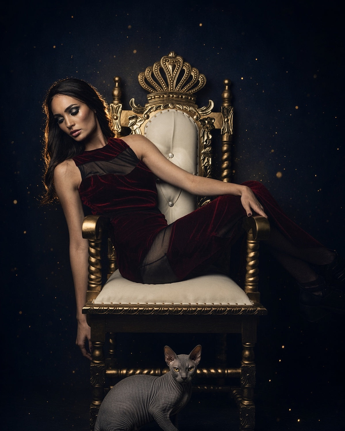 Woman seated on a crown-back throne with a cat at its base