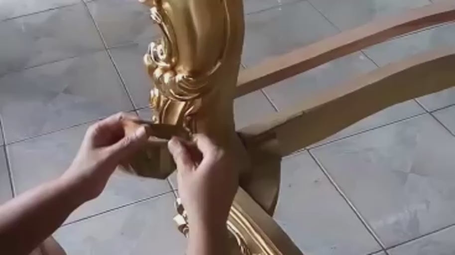 Applying the Gold Finish — The gold finish is worked around the curves and carved surfaces.