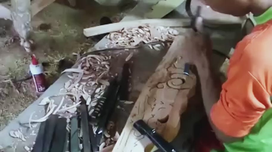 Shaping the Ornament — A craftsperson works into the wood to establish the decorative form.